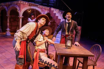 Three actors in period costumes look forward excitedly