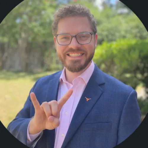 Photo of Caleb Solberg in a blue blazer and pink shirt