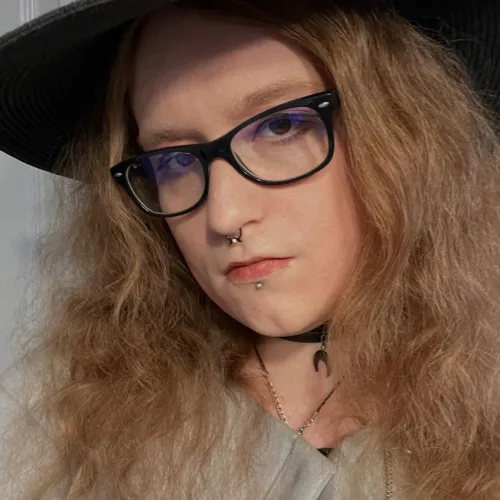 Photograph of a woman in a black hat and glasses