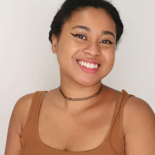 A woman with eyeliner and short black hair smiles