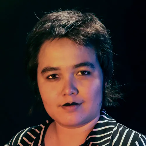 A person with short dark hair wearing a striped shirt