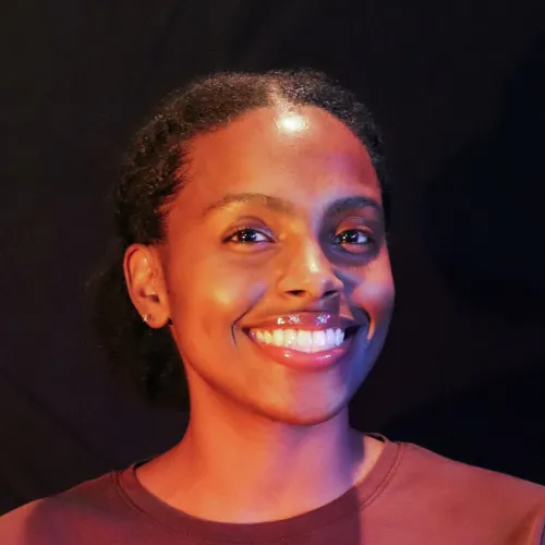 A woman with brown curly hair smiles