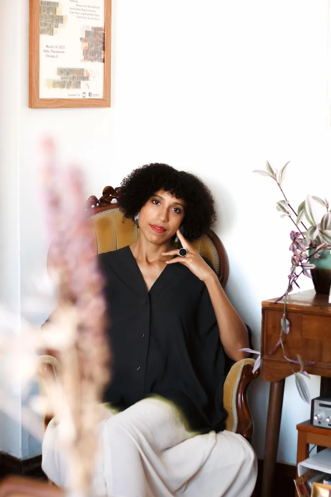 A woman with black hair leans back on an antique chair