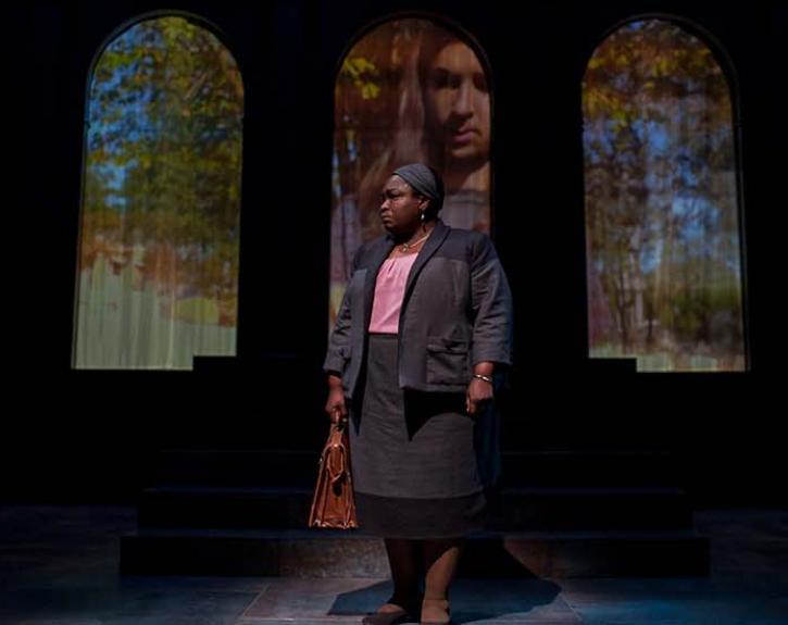 Merchant of Venice at UT Austin; Woman standing in front of projected windows