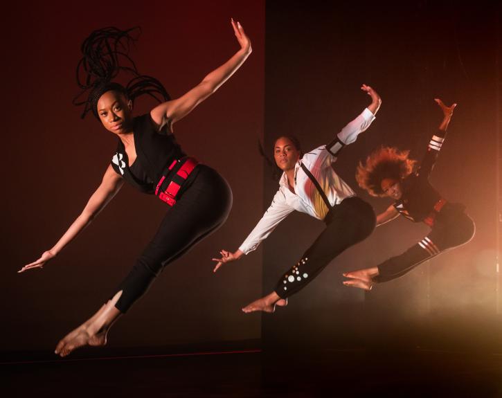 three dancers photographed in mid-jump, their toes pointed and their arms stretched out beside them