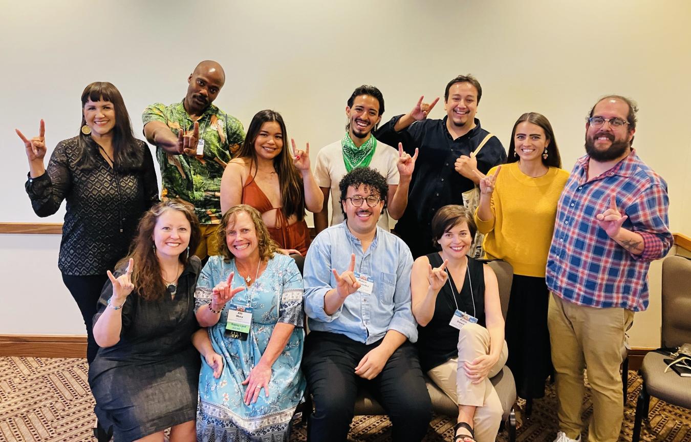 A group of 11 alumni, faculty and students pose together at the 2023 Association for Theatre in Higher Education Conference