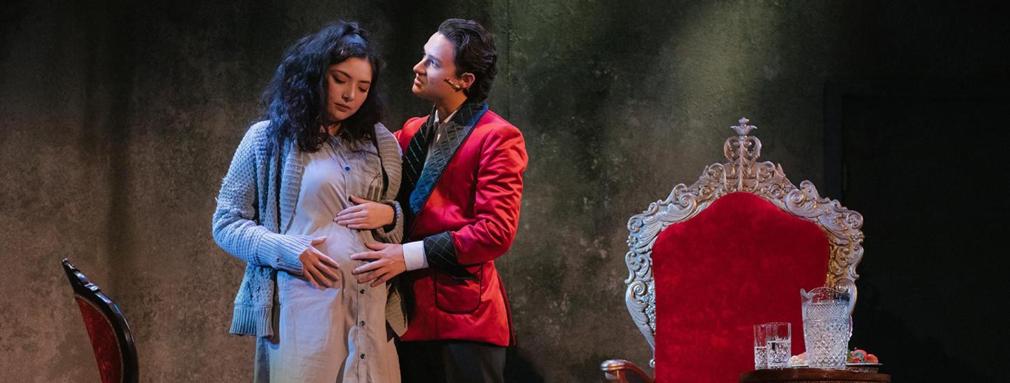 The Tasters, by Meghan Brown, with Intimacy Direction by Andy Grapko; Photo: Thomas Allison (2021) man puts his hand on a pregnant woman's belly, with his other arm around her shoulder as she looks down and he looks to the side beyond her