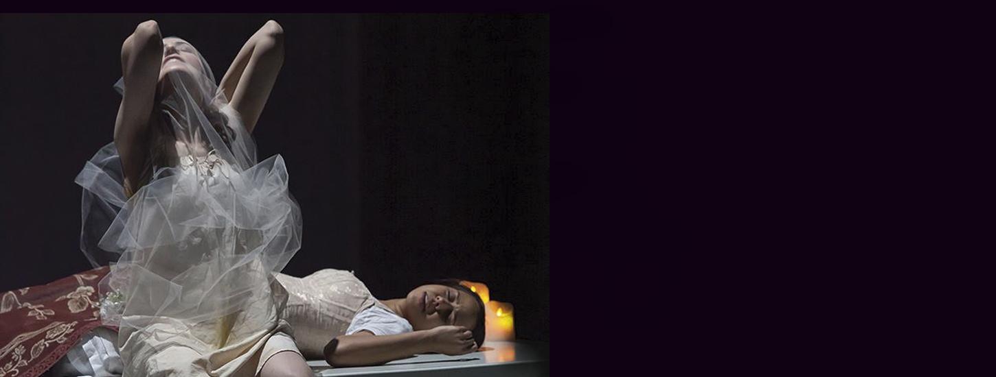 Jane Eyre production showing one woman with arms over head and another laying on a table