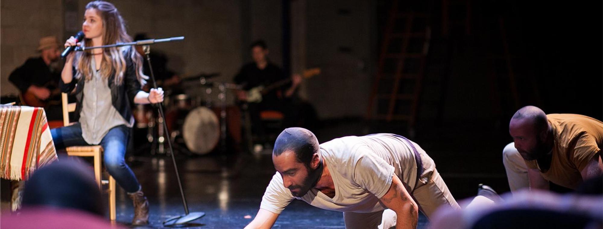 A scene from Operation Istanbul of two men crawling on the floor in front of an audience