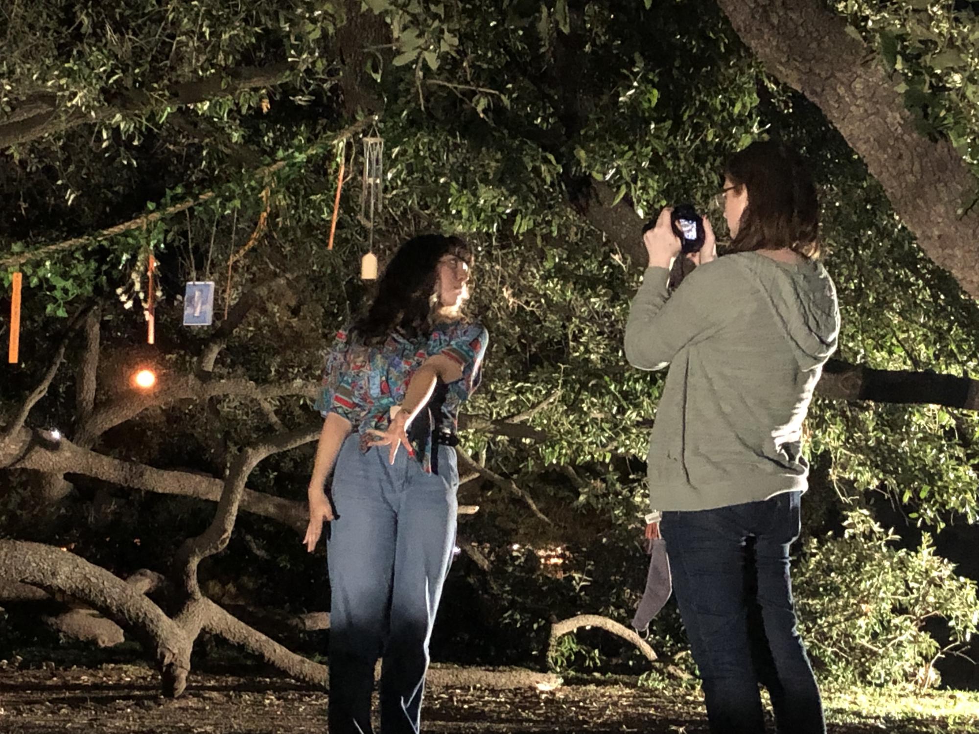 director records an ensemble member performing a dance in front of trees