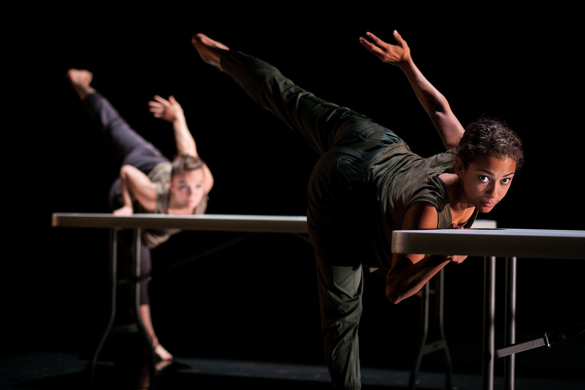 two dancers holding up leg and arm