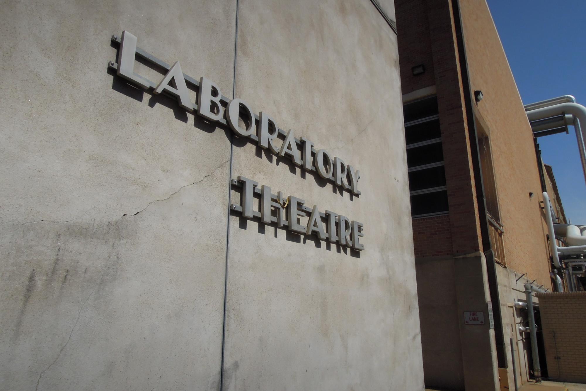 concrete wall with a metal sign spelling out "Laboratory Theatre"