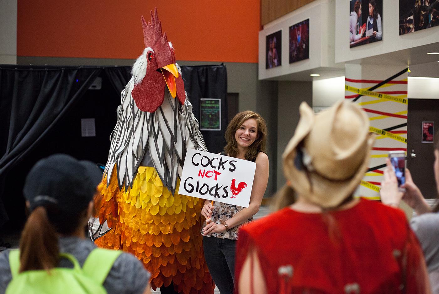 giant chicken and woman with a sign next to it