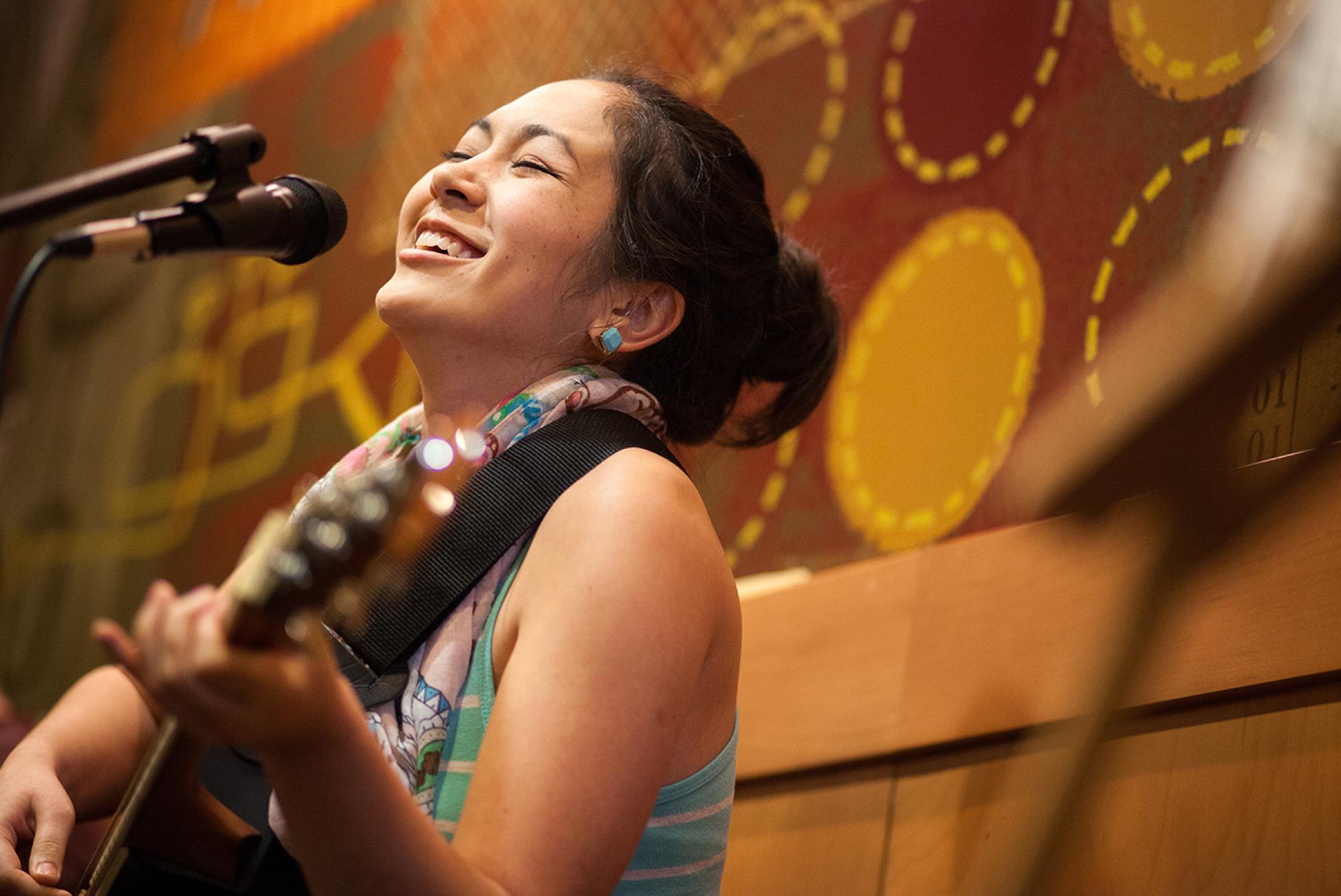 woman playing a guitar and singing