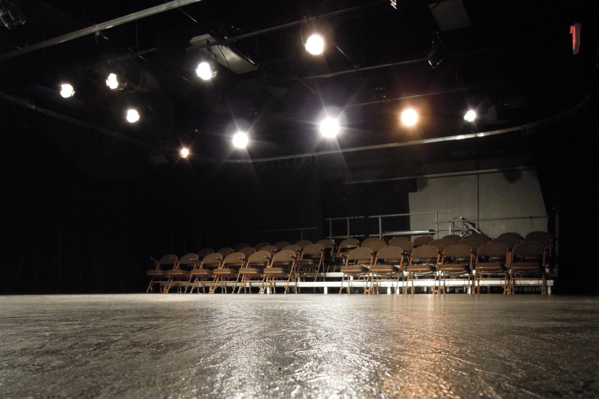 rows of foldable chairs facing an empty stage