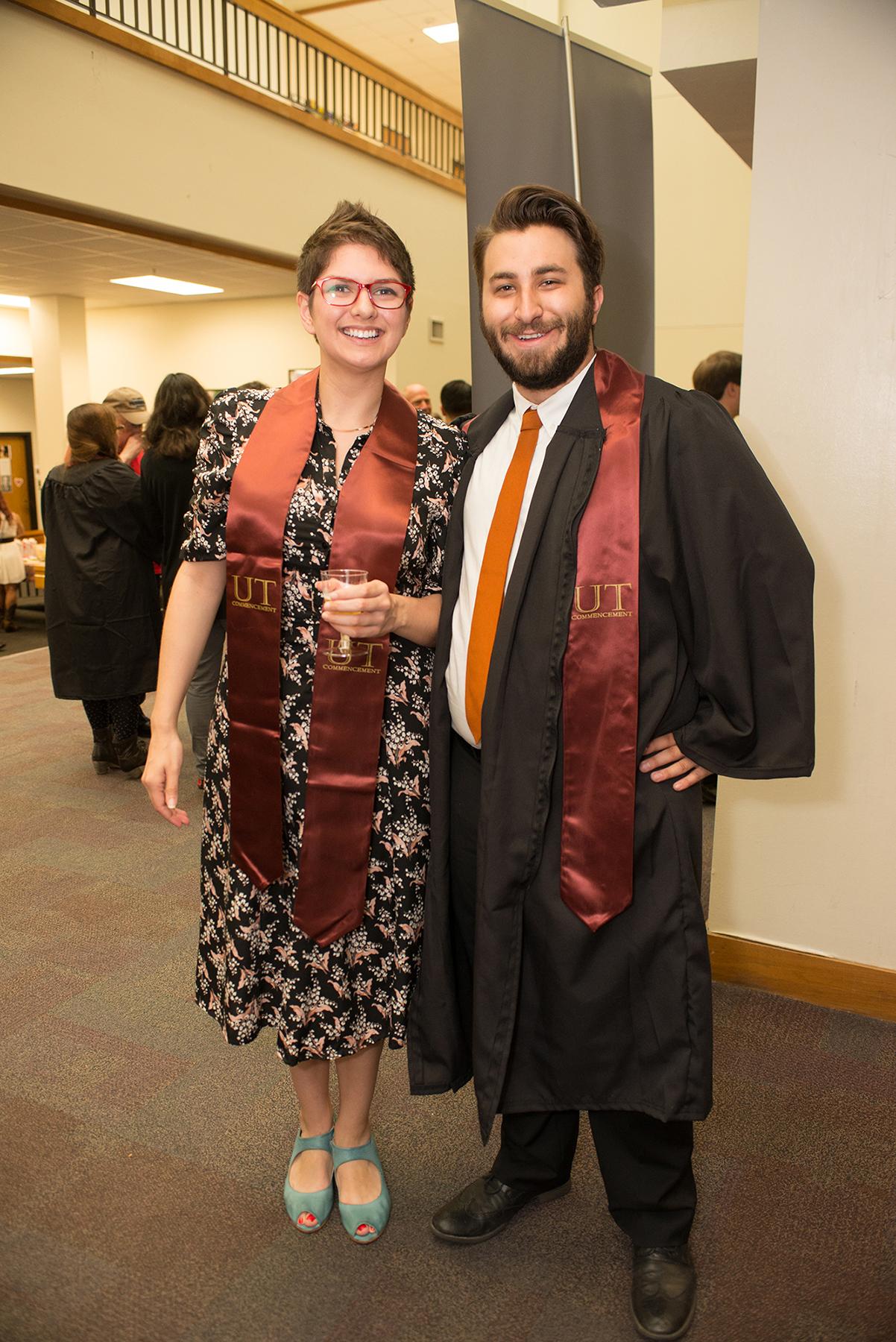 two graduates smiling
