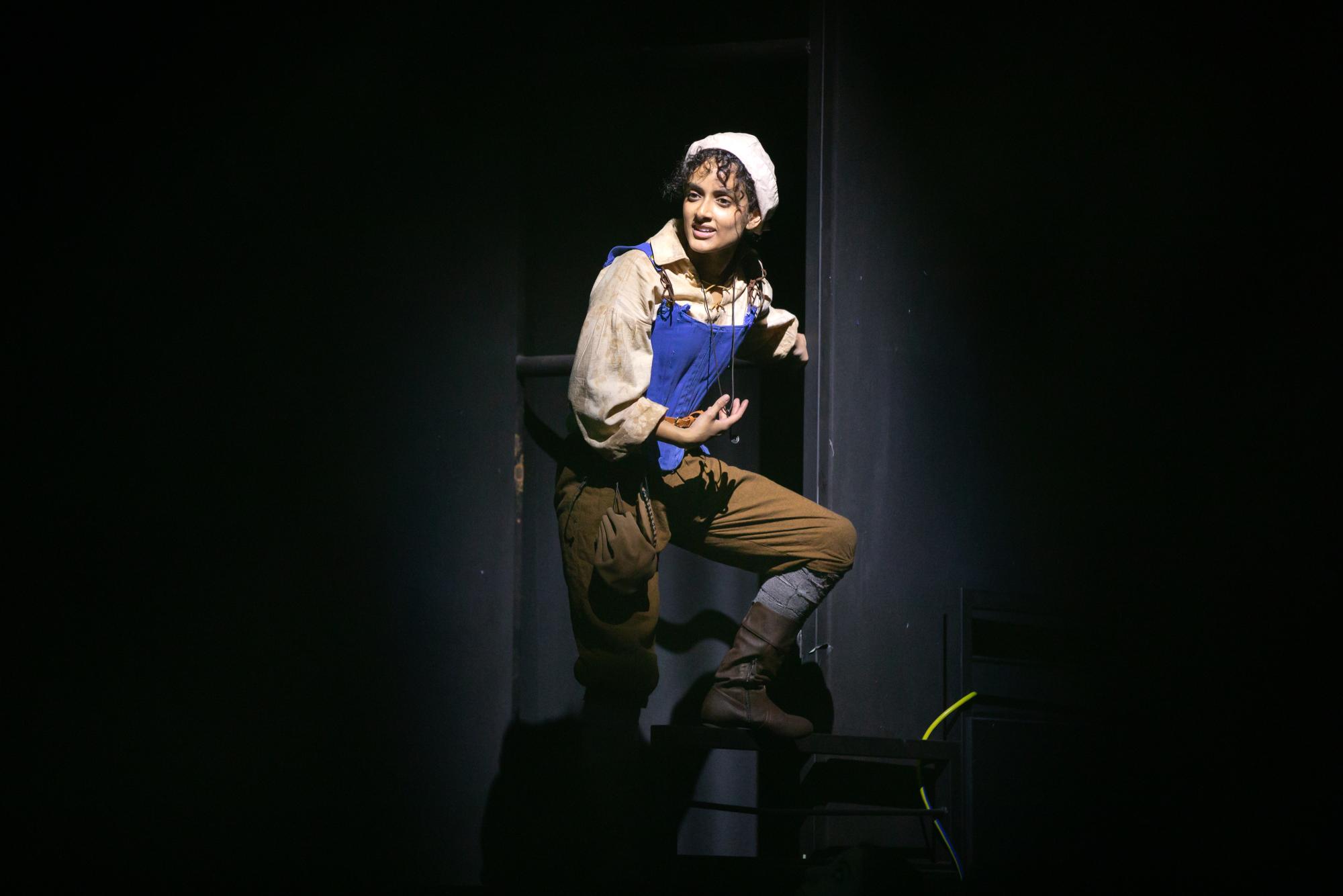 Carlise Rosa as Frau Thera stands on the walls of the theatre speaking to the audience and her fellow rebels.