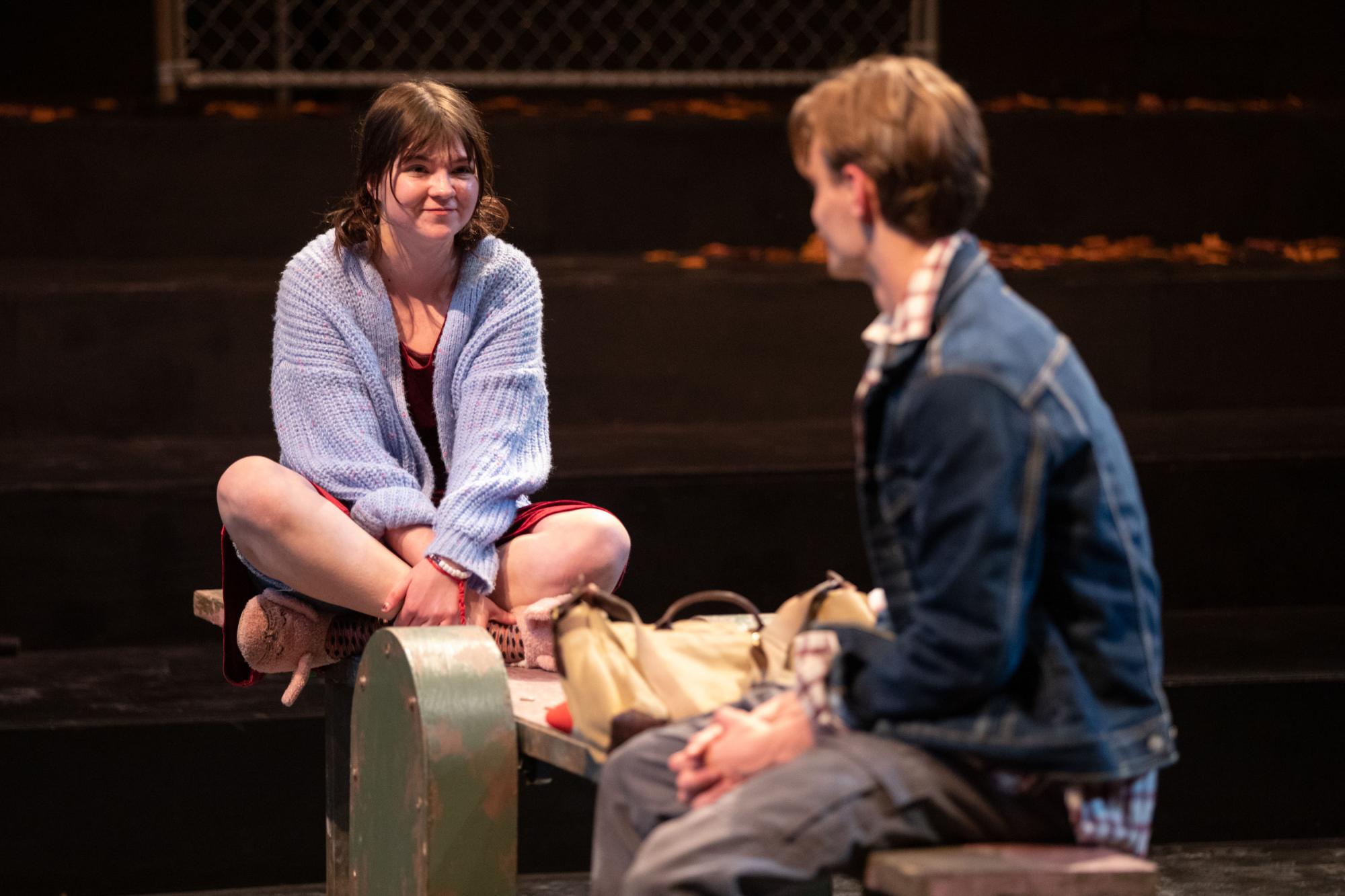 Penny Lou Zimmerman as Clara sits opposite Oliver Aaro as Arthur, her father. Smiles are on their faces.