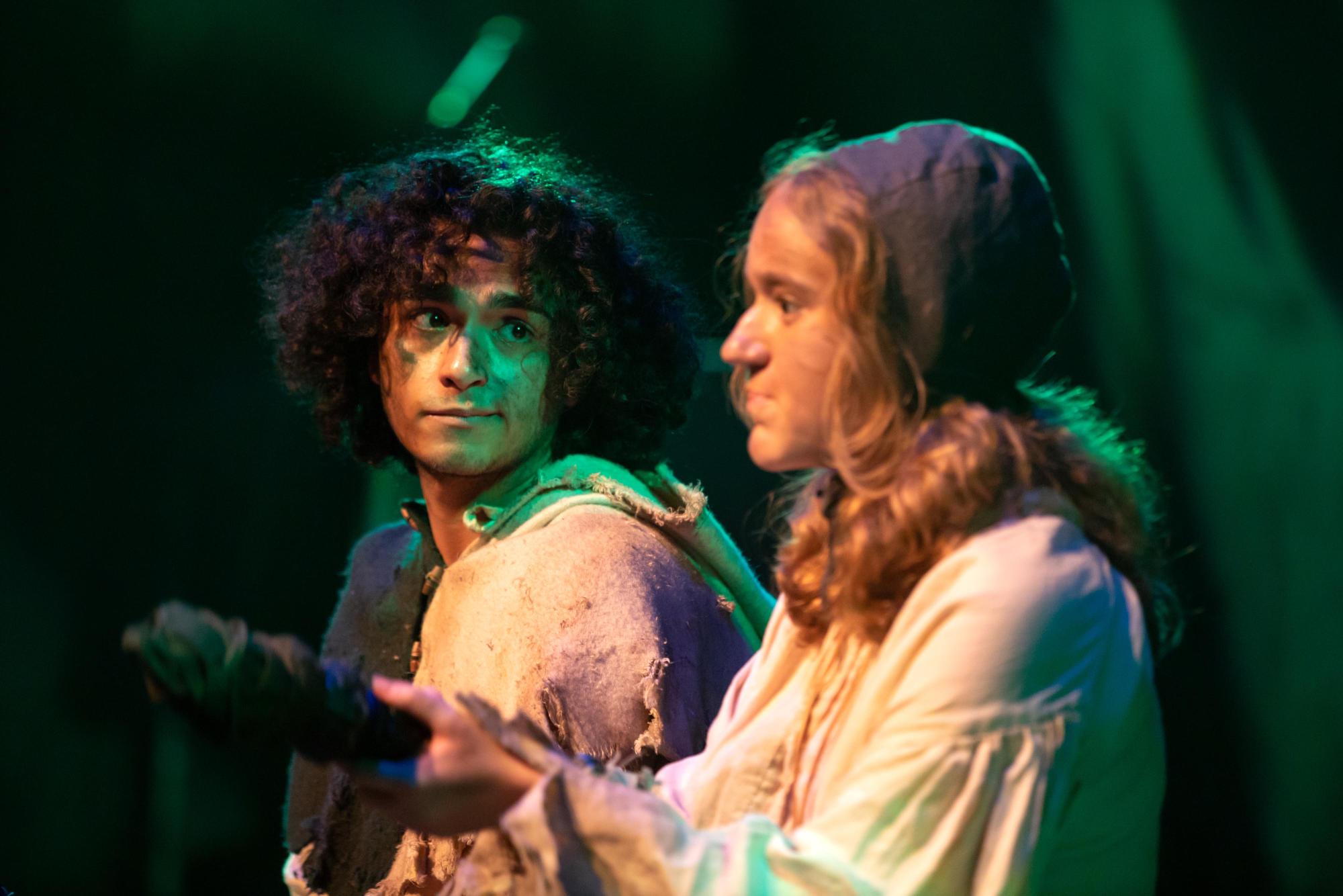 Adam Flores Jr. as Marcus and Emma Dodds as Tybee sit in the forest discussing something while on "keeping watch" duty.