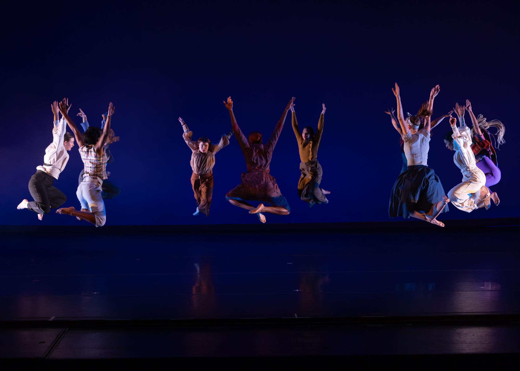 The dancers jump in the air, all in unison