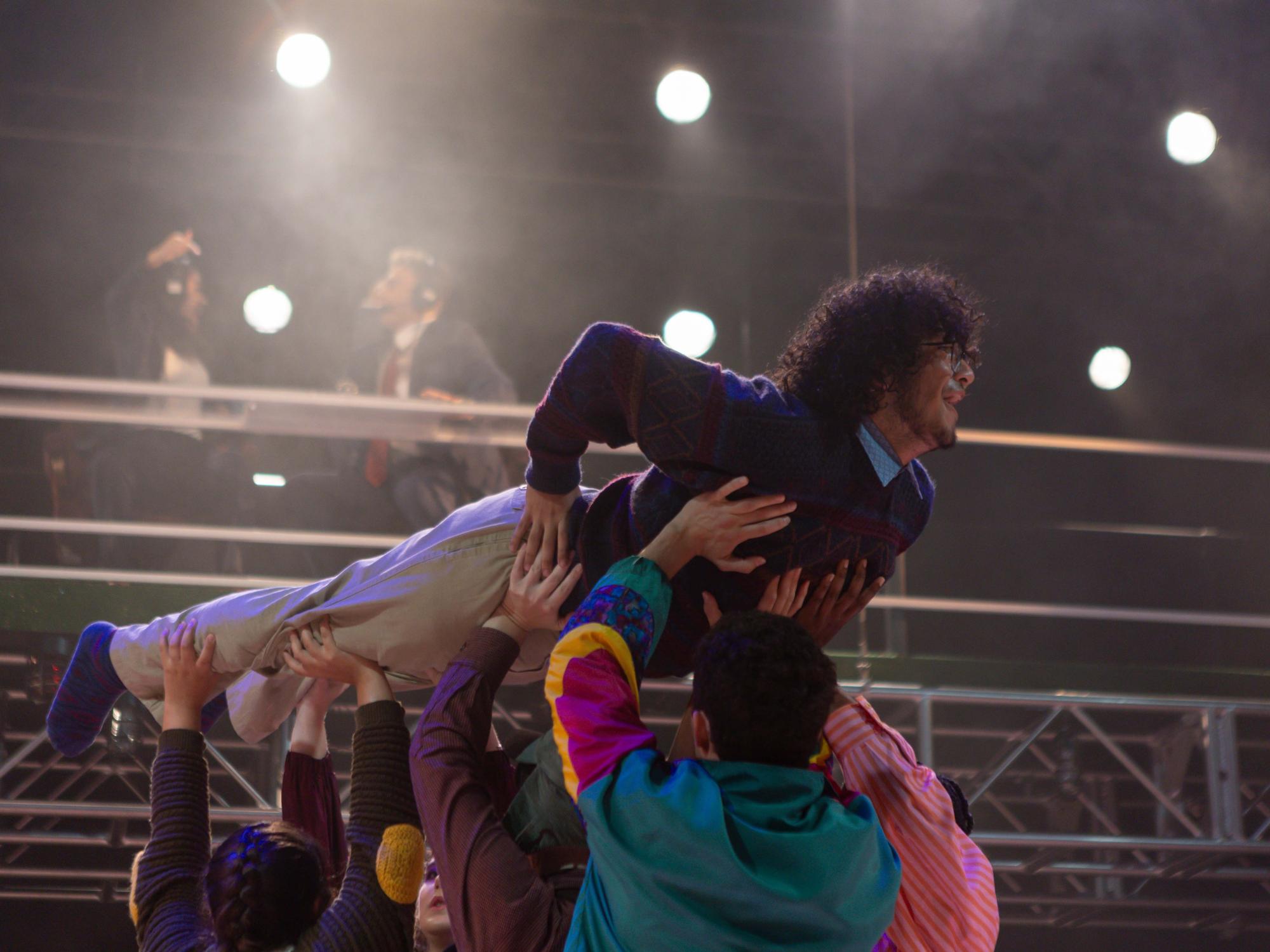 Ned, played by Adam Flores Jr., turns the bird, depicted by he, himself, becoming a turkey and turning around while lifted up by his family of castmates. The announcers are going haywire in the background of this photo.