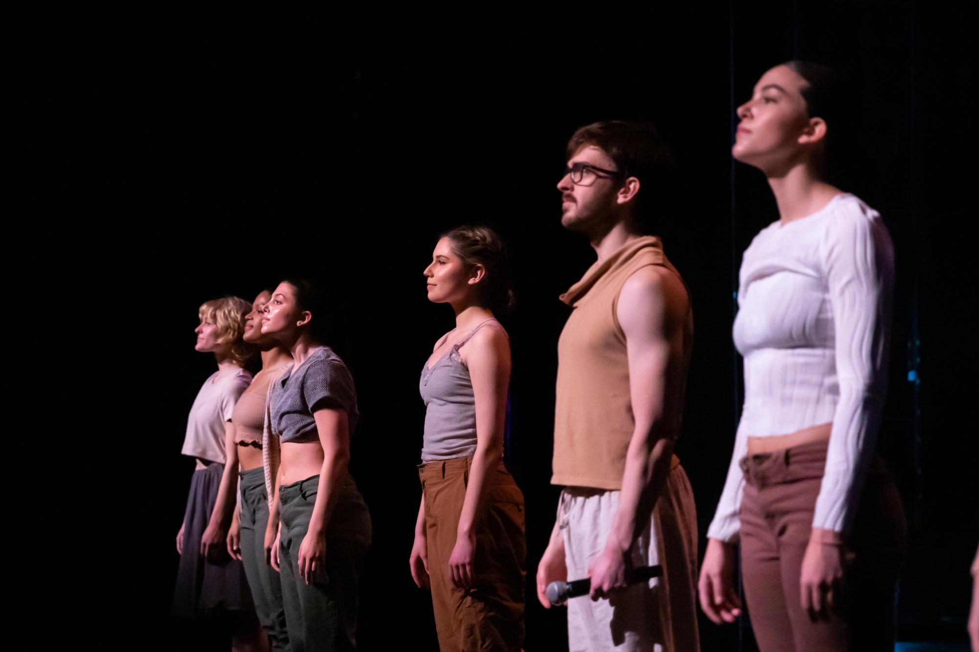 The dancers stand in a line unified and dignified.
