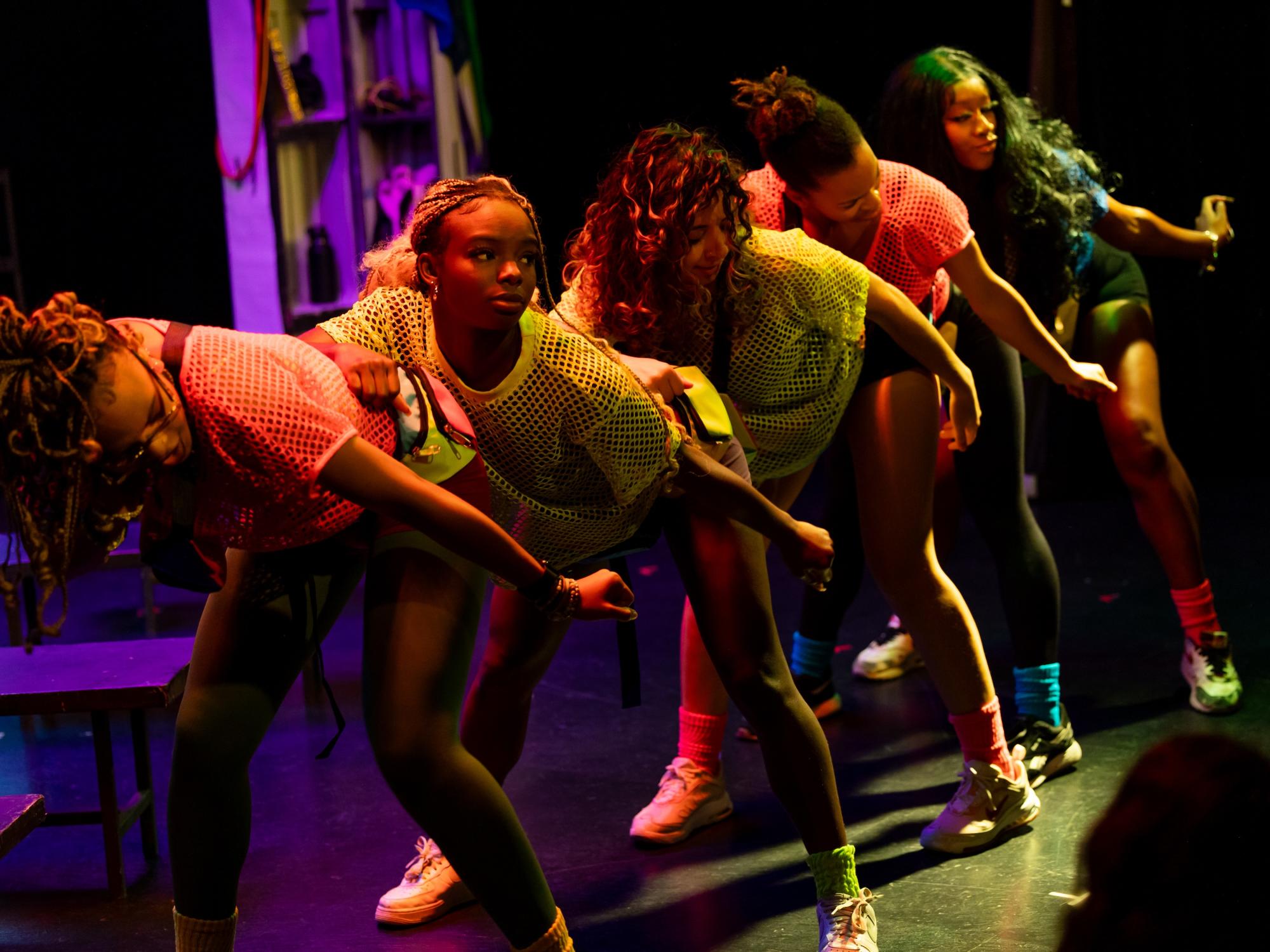 Photo of dark shage and neon lit dancers of fanny packs show