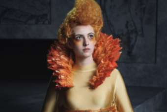 actor in yellow with orange feather collar