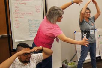 three adults participating in an interactive Summer Institute workshop