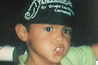 Eric Ramos as a child, wearing a black hat with white lettering on it