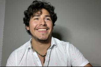 Isaac Garcia smiling and wearing a white button up