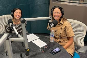 Justine Gelfman and Jenny Lavery sit behind mics, wearing headphones ahead of a radio interview