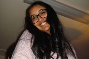 Keya Zingade smiling, wearing glasses and a pink shirt