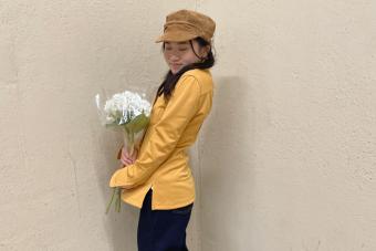 Mia Hsiung Nguyen wearing a yellow jacket and holding white flowers