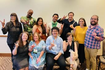 A group of 11 alumni, faculty and students pose together at the 2023 Association for Theatre in Higher Education Conference