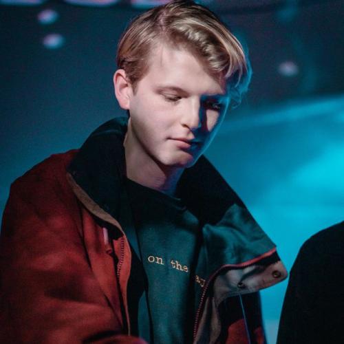 man with short blonde hair wearing a jacket and looking down