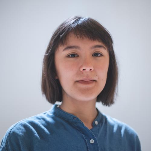 woman with short brown hair and bangs wearing a blue button up
